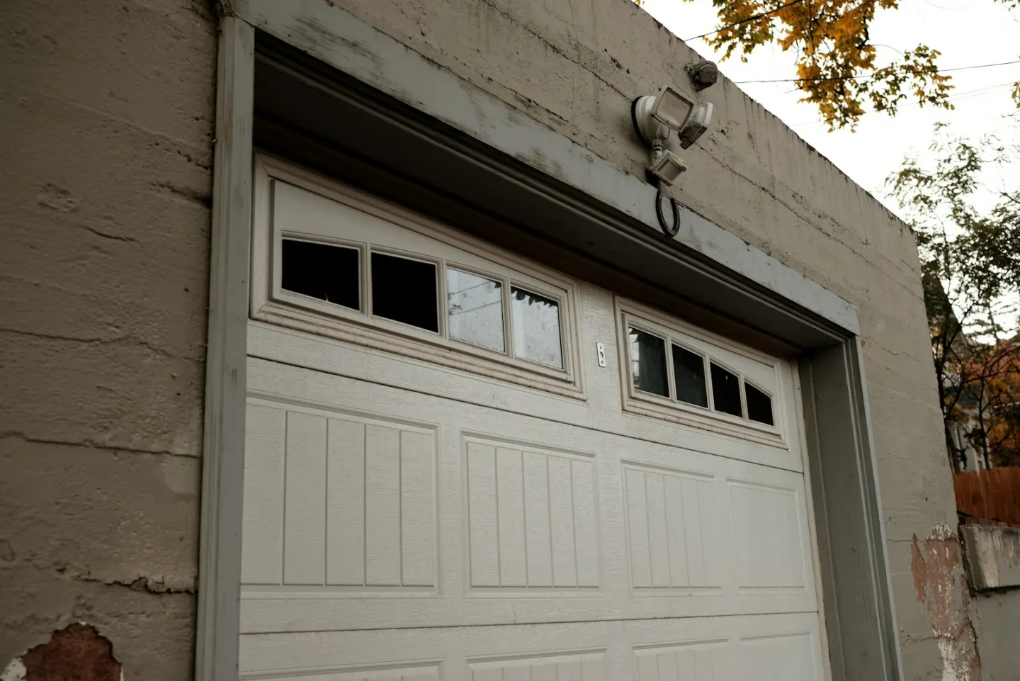 Closed white sectional garage door used as contextual spring-repair imagery